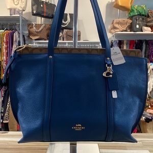 Blue leather Coach tote with brown signature strip on top.